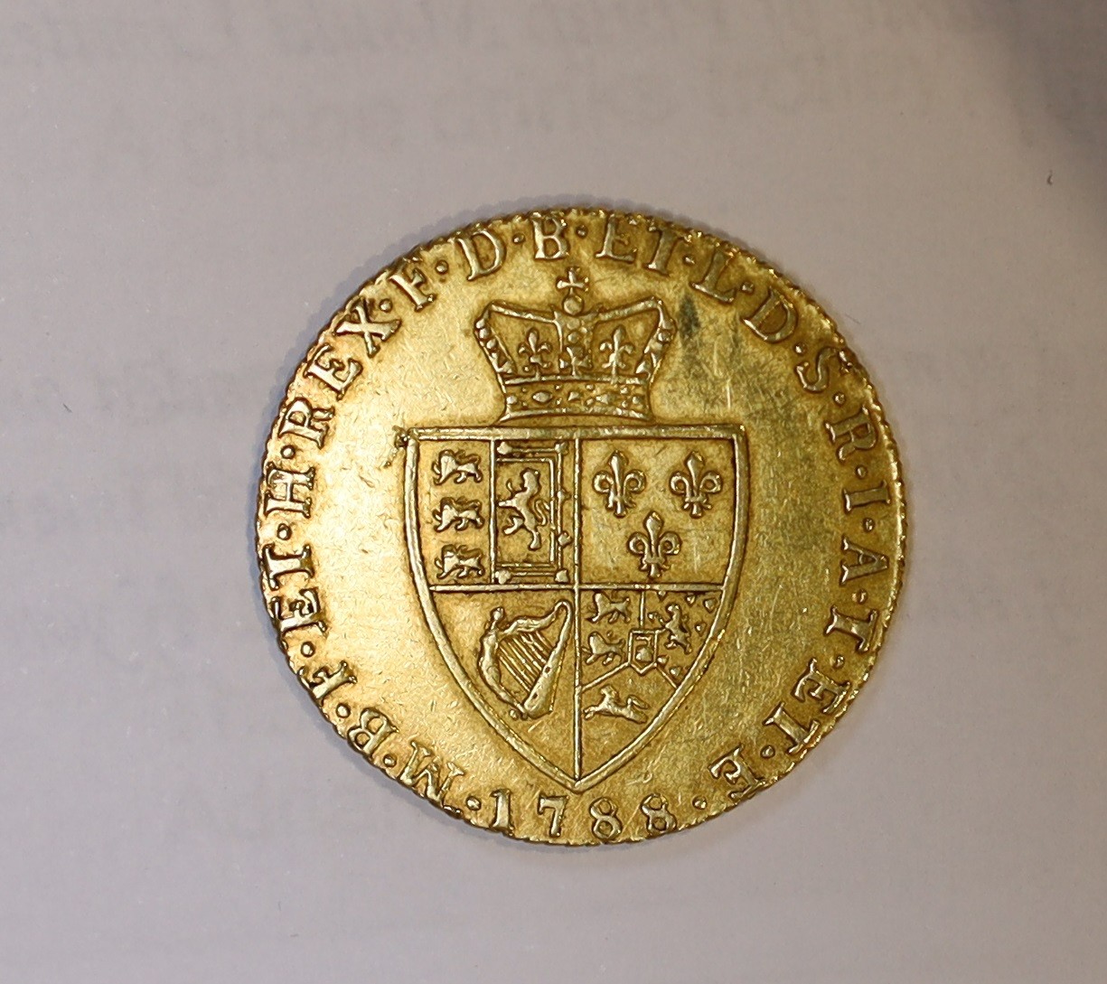 A George III 1788 gold spade guinea, good VF.